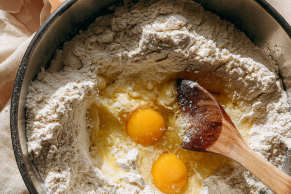 a-large-mixing-bowl-filled-with-flour-cracked-eggs