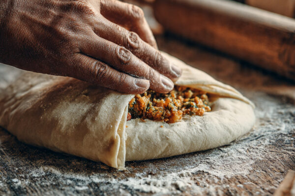 close-up-of-a-stuffed-paratha-being-sealed-by-hand