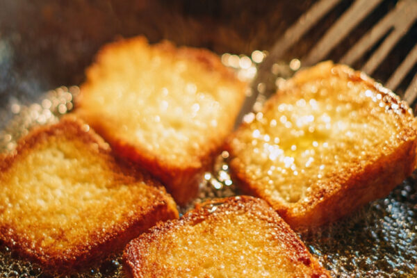 close-up-of-white-bread-slices-being-deep-fried-in