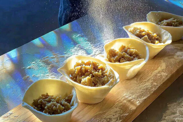 hands-forming-samosa-cones-from-rolled-dough-halve