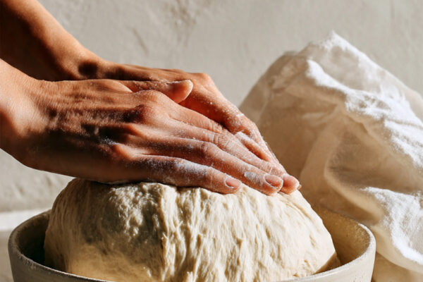 hands-kneading-smooth-elastic-dough-on-a-lightly-f