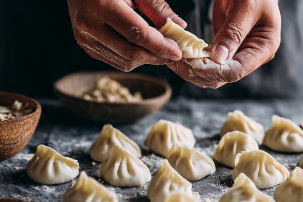close-up-shot-of-hands-filling-dumpling-wrappers-w
