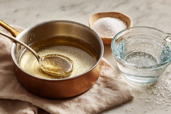 small-saucepan-with-sugar-syrup-being-stirred-gent
