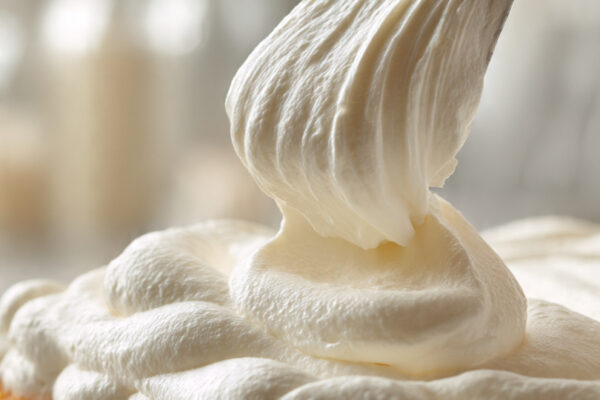 soft-whipped-cream-being-spread-over-soaked-tres-l