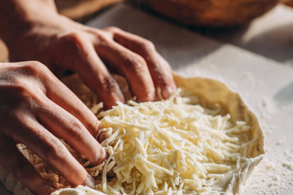 a-round-piece-of-soft-dough-flattened-by-hand-with